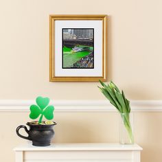 a potted plant sitting on top of a white table next to a framed photo