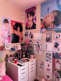 a bedroom with posters on the wall and pictures on the dressers in front of it