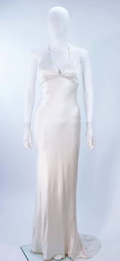 a mannequin wearing a white dress on display in front of a white background