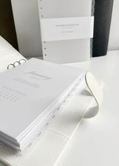 a white binder sitting on top of a table next to some folders and papers