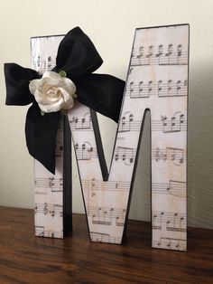 the letter m is decorated with musical notes and a flower in it's center