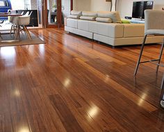 a living room with hard wood flooring and white couches in the center area