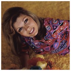 a woman is laying on the floor with her stuffed animal and smiling at the camera