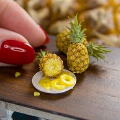 a miniature pineapple and an egg on a wooden table with yellow condiments