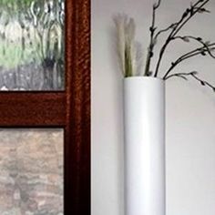 there is a vase with some flowers in it next to a window and a door