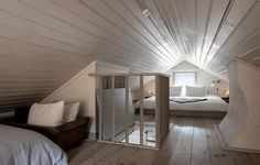 an attic bedroom with white walls and wood floors