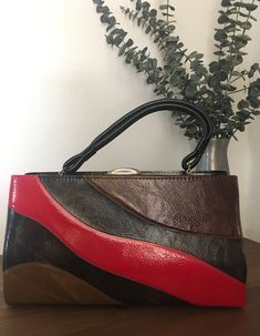 "1960s 1970s Dover Handbag, Vintage Top Handle Purse, Vintage Accessory Retro 1960s 1970s handbag with an unusual wave design on the front of the bag in multiple colors and solid black on the back of the bag. Doubled black handle strap. Gold tone metal frame with a thumb lift closure that works well and closes tightly with that lovely \"snapping\" sound letting you know that everything inside is safe and secure. Opens to black fabric lining with three compartments.  Two on the outer side of the Retro Red Rectangular Shoulder Bag, Retro Red Top Handle Satchel, Retro Red Top Handle Shoulder Bag, Red Retro Top Handle Shoulder Bag, Retro Vintage Brown Rectangular Shoulder Bag, Retro Red Satchel With Detachable Handle, Retro Red Satchel Shoulder Bag, Retro Red Shoulder Satchel, Retro Red Rectangular Satchel