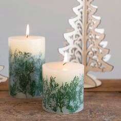 two candles sitting on top of a wooden table