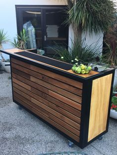 a wooden planter sitting on top of a sidewalk