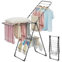 an ironing board with clothes hanging on it and a drying rack holding towels, sweaters, and other items