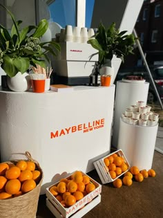 some oranges are sitting in baskets on a table next to other containers and plants