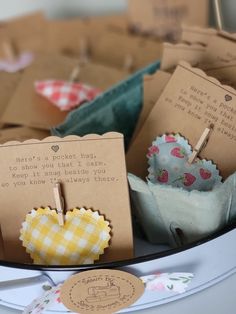 several small cupcakes are sitting on a table with tags attached to the top