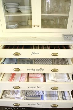 the drawers are organized and labeled with labels for dishes, napkins, and glasses