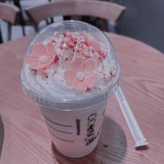 a plastic cup filled with whipped cream and pink flowers