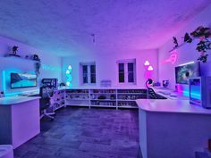 a room filled with lots of computers and desks covered in neon lights on the walls