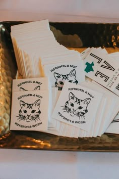 small business cards on a gold tray with black and white inked cats in the middle