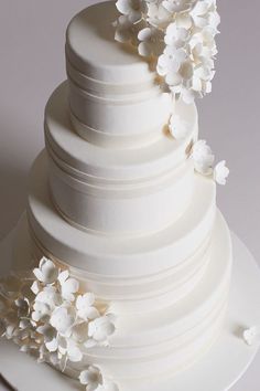 a white wedding cake with flowers on top