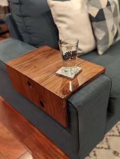 a wooden table sitting on top of a couch next to a blue couch with pillows