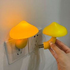 someone is turning on the light switch with two mushrooms attached to it, both yellow