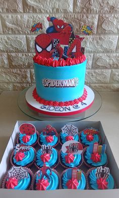 a spiderman birthday cake and cupcakes in a box