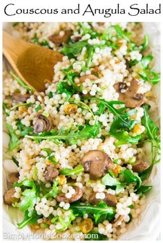 a bowl filled with rice, mushrooms and spinach on top of a wooden spoon