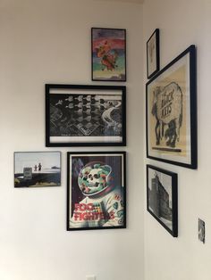 a wall with many framed pictures on it