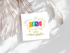 a happy new year greeting card with fireworks and numbers on it next to palm leaves