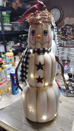 a lighted snowman sitting on top of a wooden table