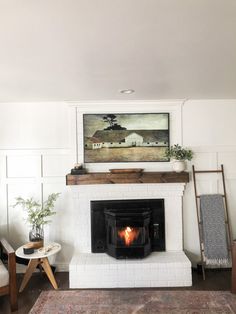 a living room with a fire place next to a chair and rug on the floor