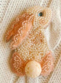 a beaded dog brooch sitting on top of a white sweater