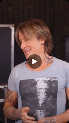 a man with tattoos standing in front of a refrigerator