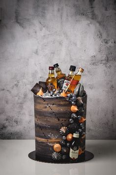 a wooden bucket filled with liquor bottles on top of a white table next to a wall