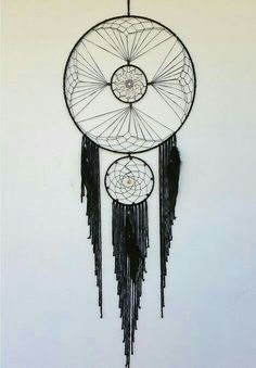 a black and white dream catcher hanging on the wall