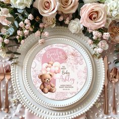 there is a plate with a teddy bear on it and pink flowers in the background