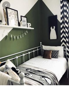 a bedroom with green walls and black and white decor