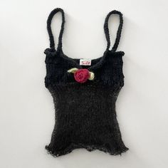 a knitted black tank top with a red rose on it