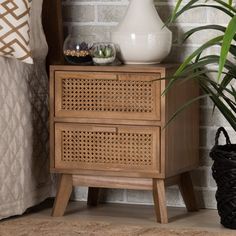 a white vase sitting on top of a wooden cabinet next to a plant in a pot