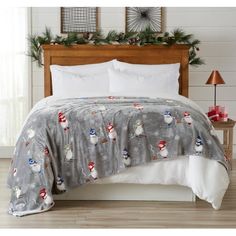 a bed with a snowman comforter and christmas decorations