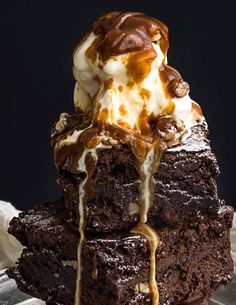 brownies baked in a cast iron skillet are topped with ice cream and caramel drizzle