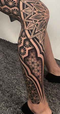 a man's leg with an intricate tattoo on it