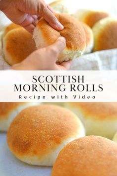 a person holding a piece of bread in front of other rolls on a table with text overlay that reads scottish morning rolls recipe with video