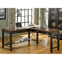 a wooden desk sitting on top of a hard wood floor next to a book shelf