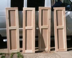 three unfinished wooden doors sitting next to a van