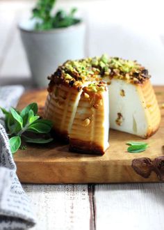 some food is sitting on a wooden cutting board next to a potted green plant