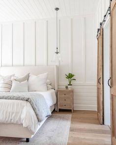 a bedroom with white walls and wood floors