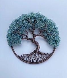 a brooch with a tree in the middle and roots on it's side