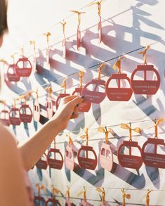 a woman is looking at the red signs that are hanging on the wall in front of her