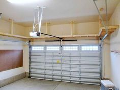 an empty garage with a basketball hoop hanging from the ceiling and overhead lighting above it