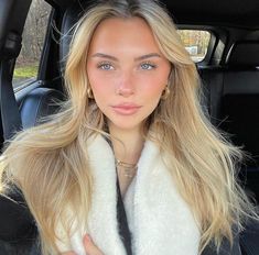 a woman sitting in the back seat of a car with her hand on her hip