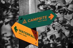 two green and yellow signs pointing to campsite next to each other on a wooden pole